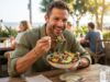 Man eating a healthy avocado salad bowl in bright morning sunlight.