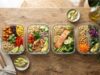 A top down view of healthy clean meals in glass containers on a table.